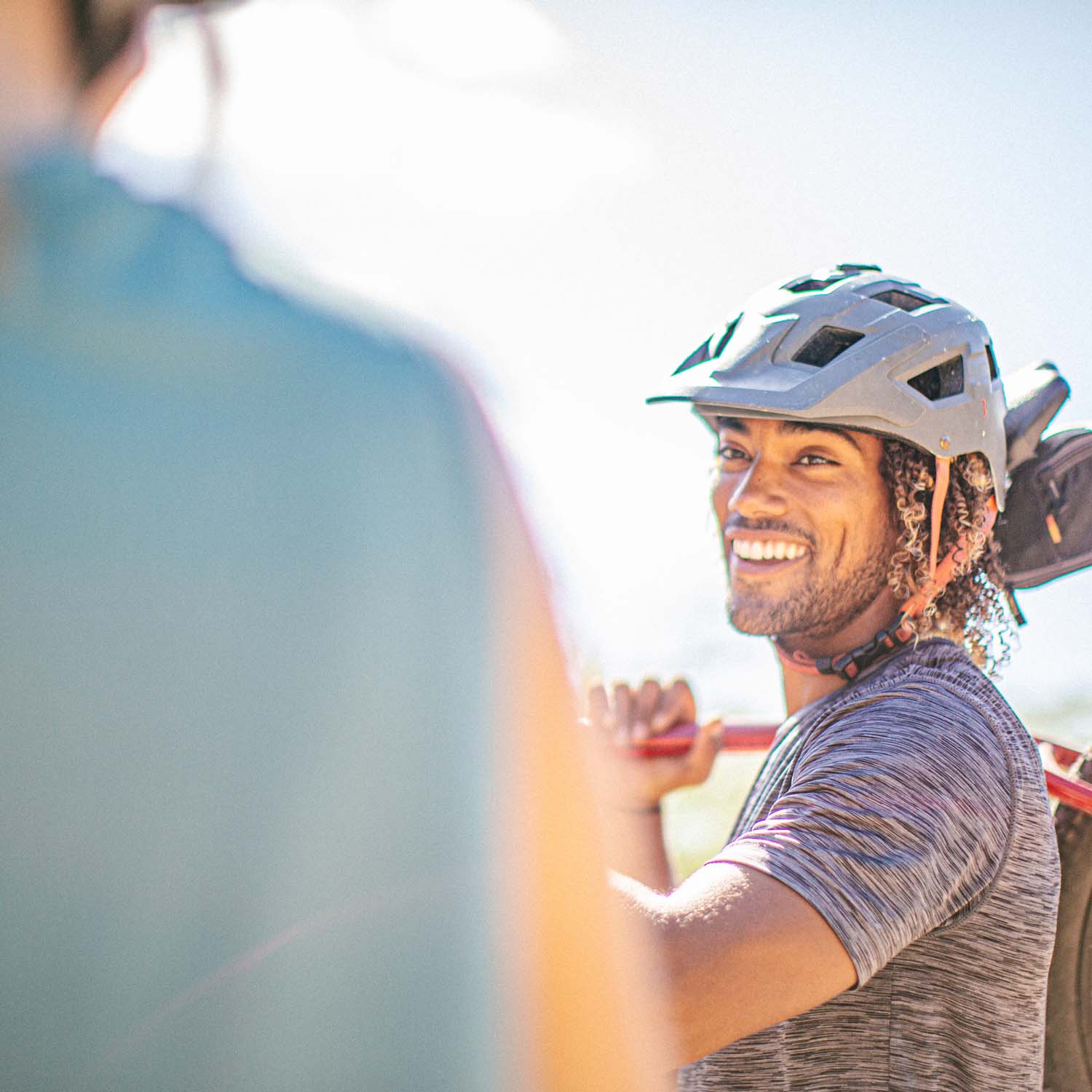 Male in helmet holding bike