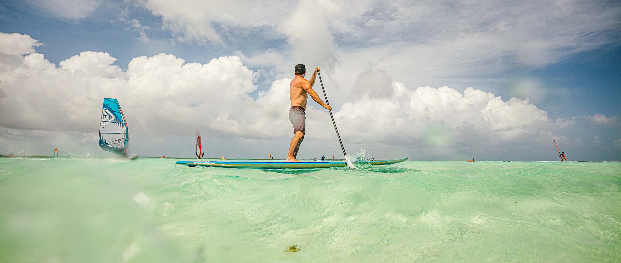 Man staande op paddleboard in water