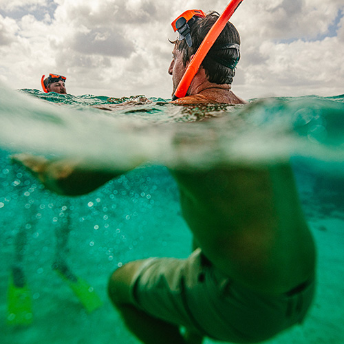 Man drijvend in het water met een snorkel