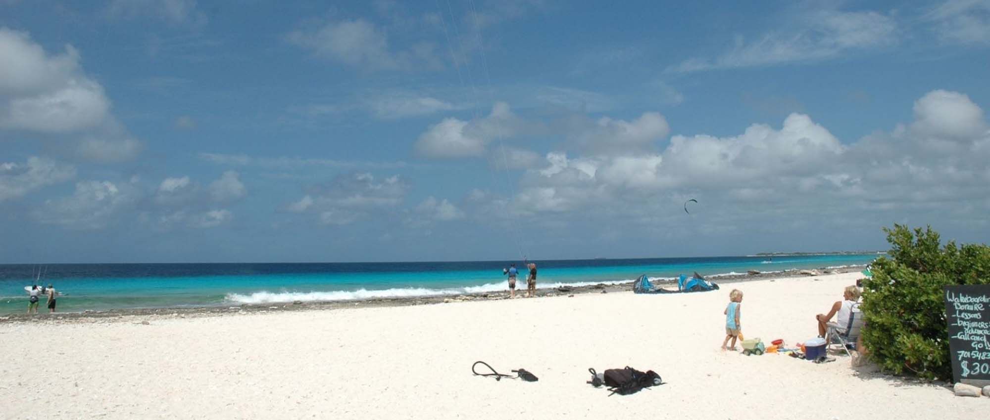 People flying kites and enjoying the white sand beach