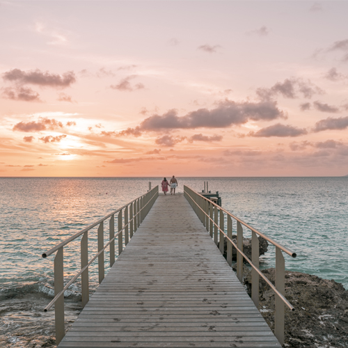 Couple walking on pier into the distance