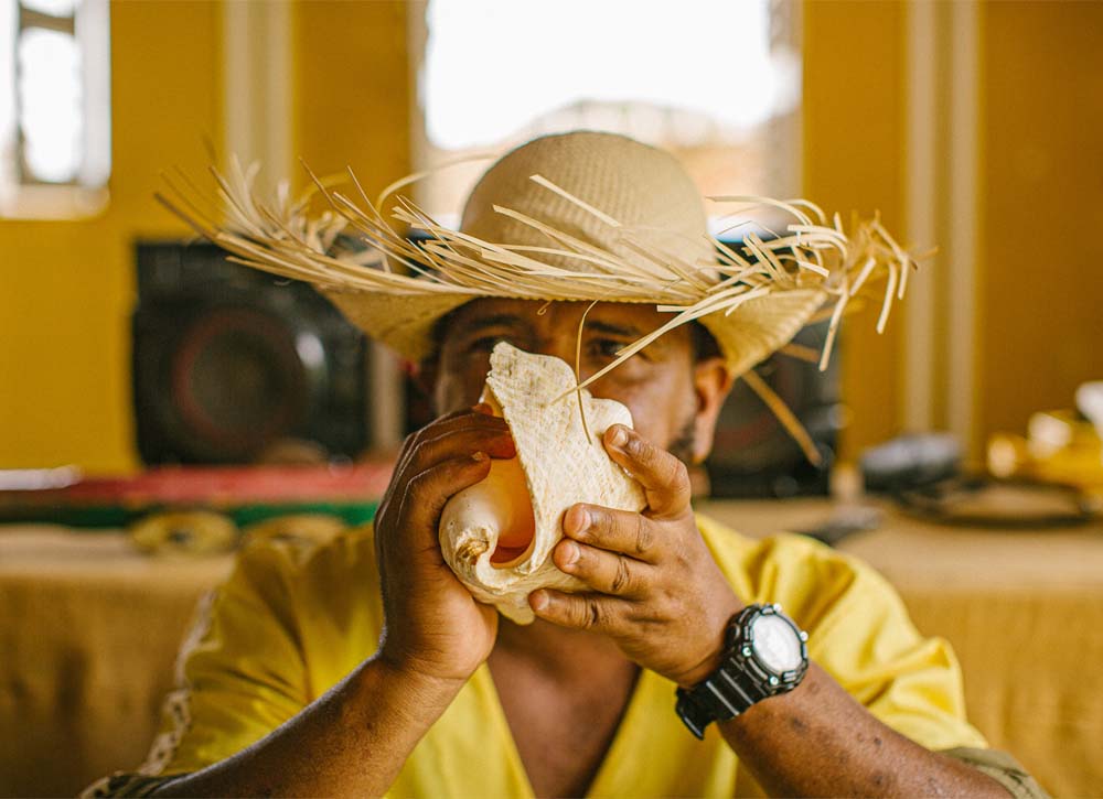 Man blowing into conch shell