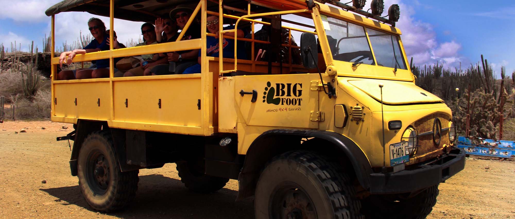 Bright yellow safari truck with people aboard
