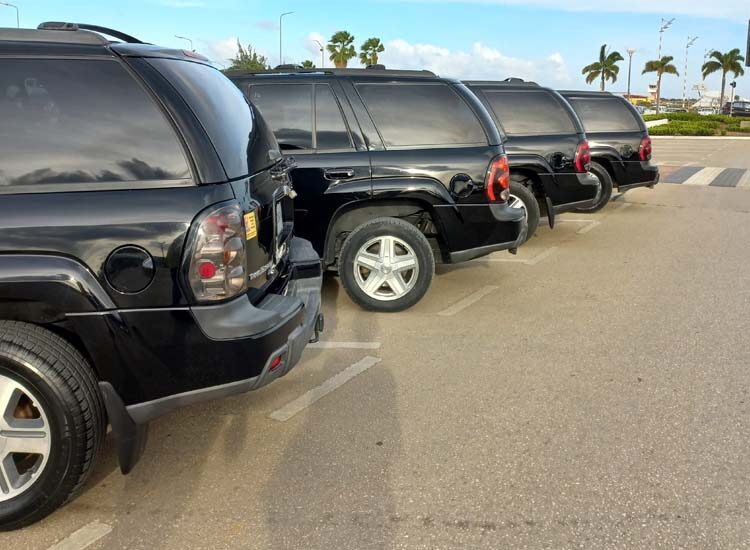 Vier zwarte terreinwagens in een rij op een parkeerplaats