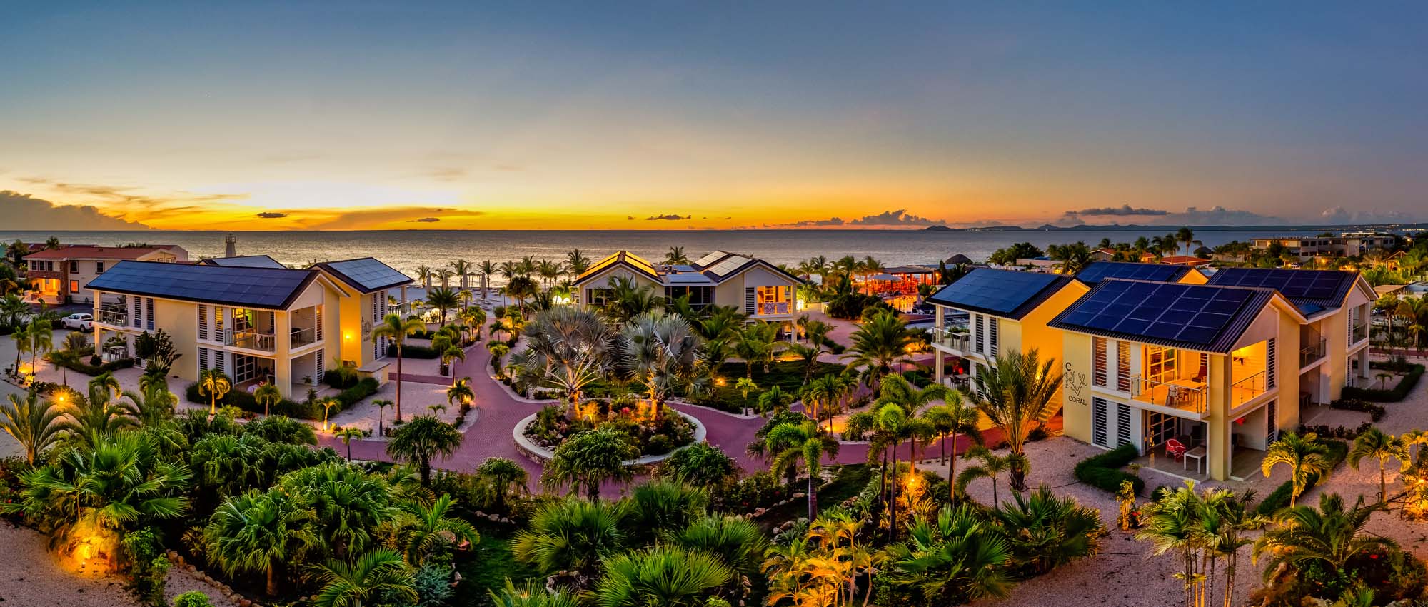 Panoramisch uitzicht op het hotelterrein met oceaanzicht tijdens zonsondergang