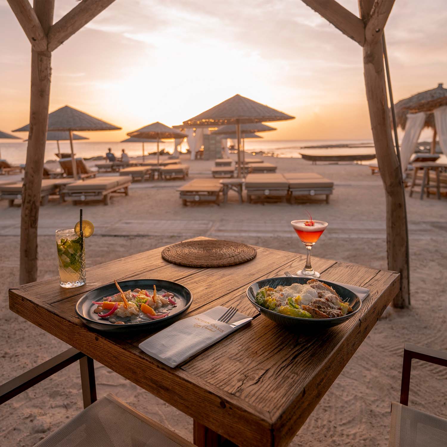 Table set for two on beach at sunset