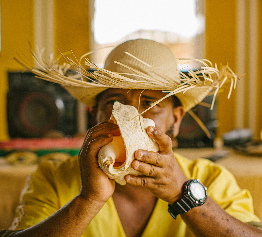 Man blowing into conch shell