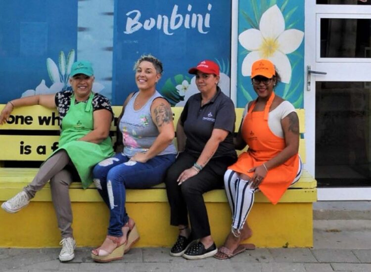 Group of ladies posing under Maya' Corner Cafe sign