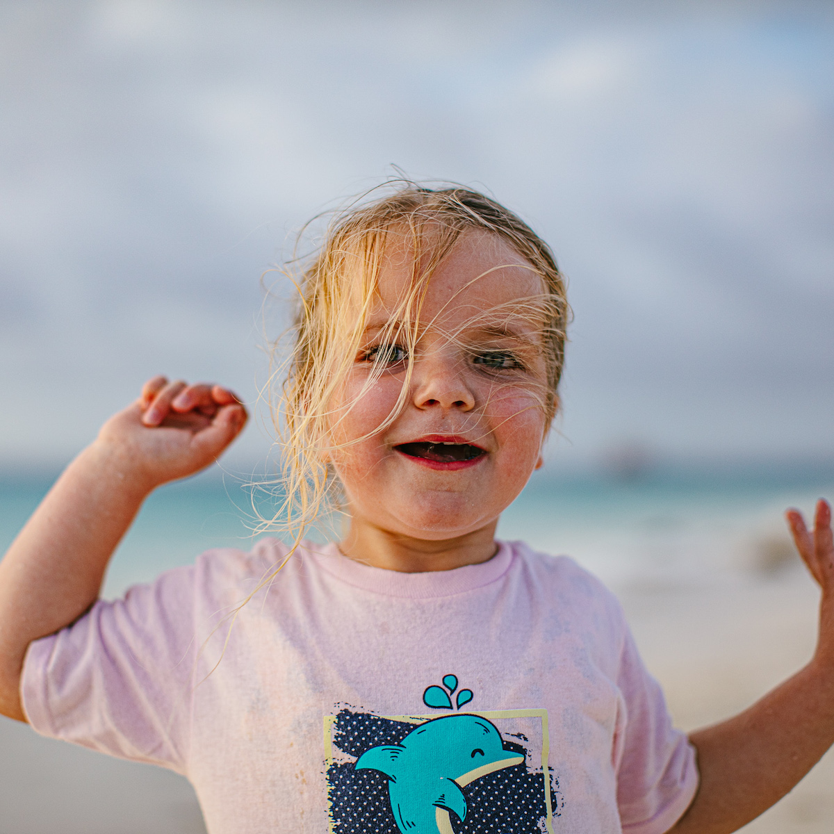 Child smiling at camera on beach