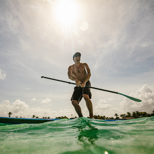 Man staande op paddleboard op water