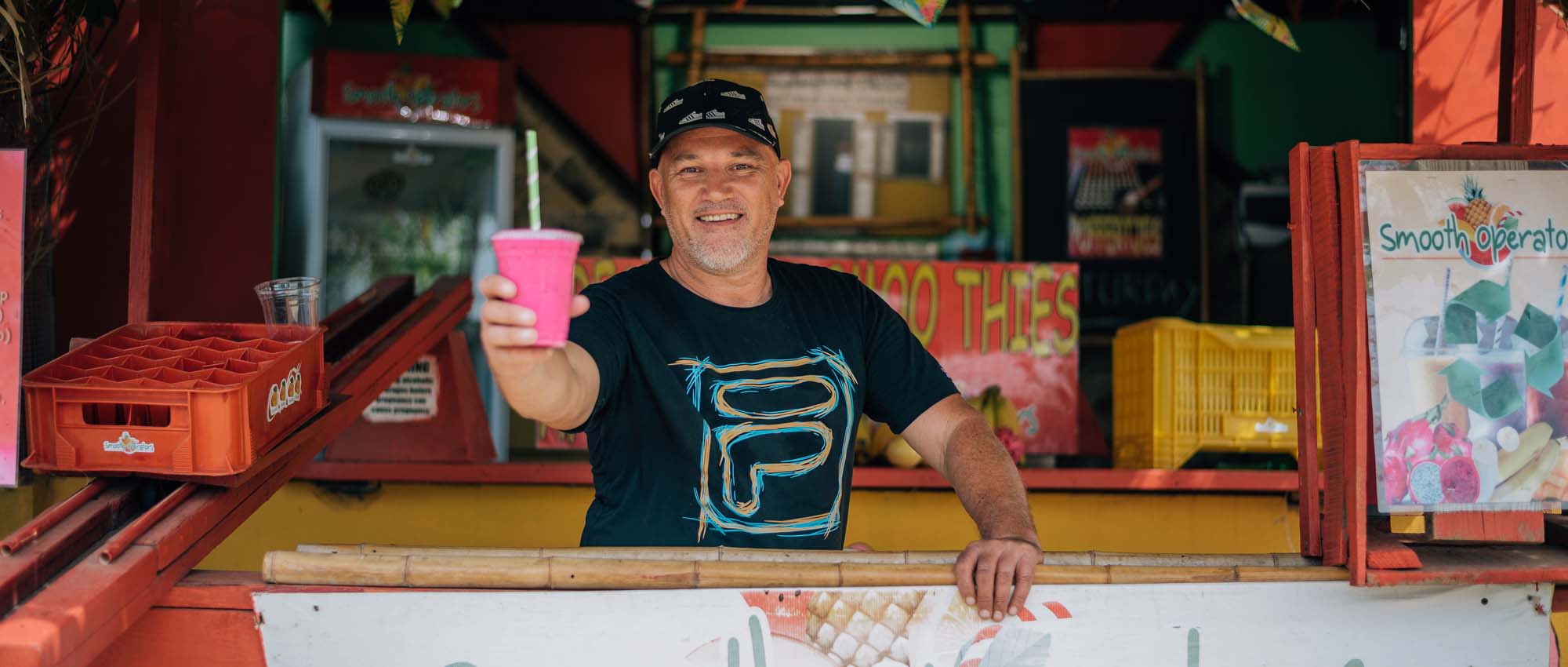 Man holding smoothie and smiling at camera