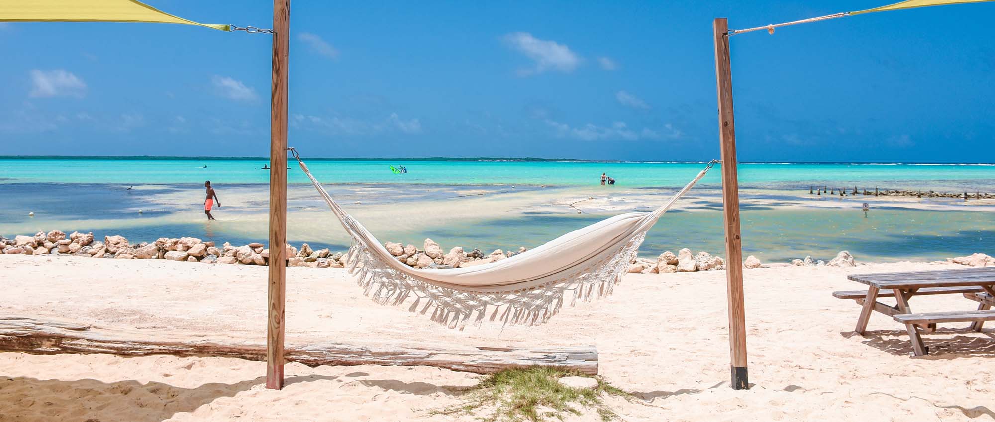 White hammock attached to two poles on the beach