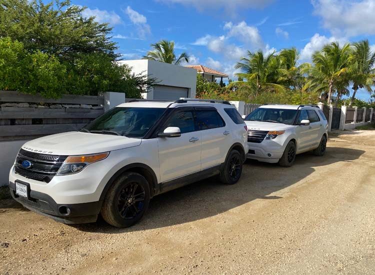 Two white SUVs parallel parked